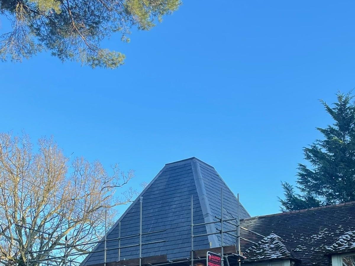 Steep slate roof under full scaffolding during a detailed roof inspection