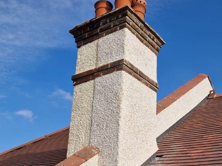 Rendered chimney stack with new pots weathered into a clay tile roof
